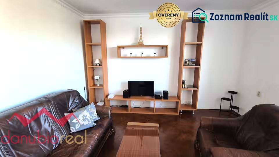 Living room in a 3-room apartment with brown furnishings and Eiffel Tower decor.