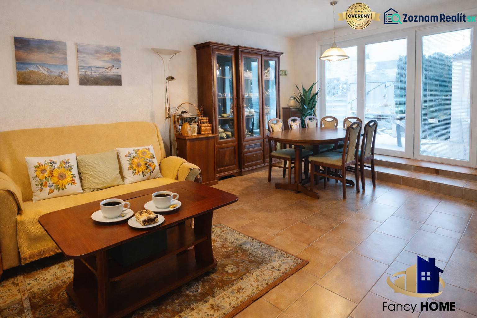 Living room in a family house with a dining table, shelves, and a sofa.
