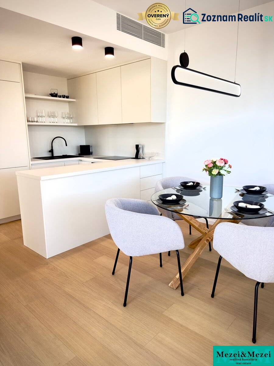 A kitchen in a 3-room apartment with a wooden decor floor, dining table, and chairs.