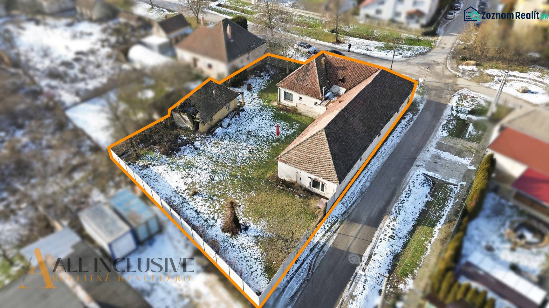 Plots for residential use in Zemné with snow-covered roofs and a garden bordered by an orange line.