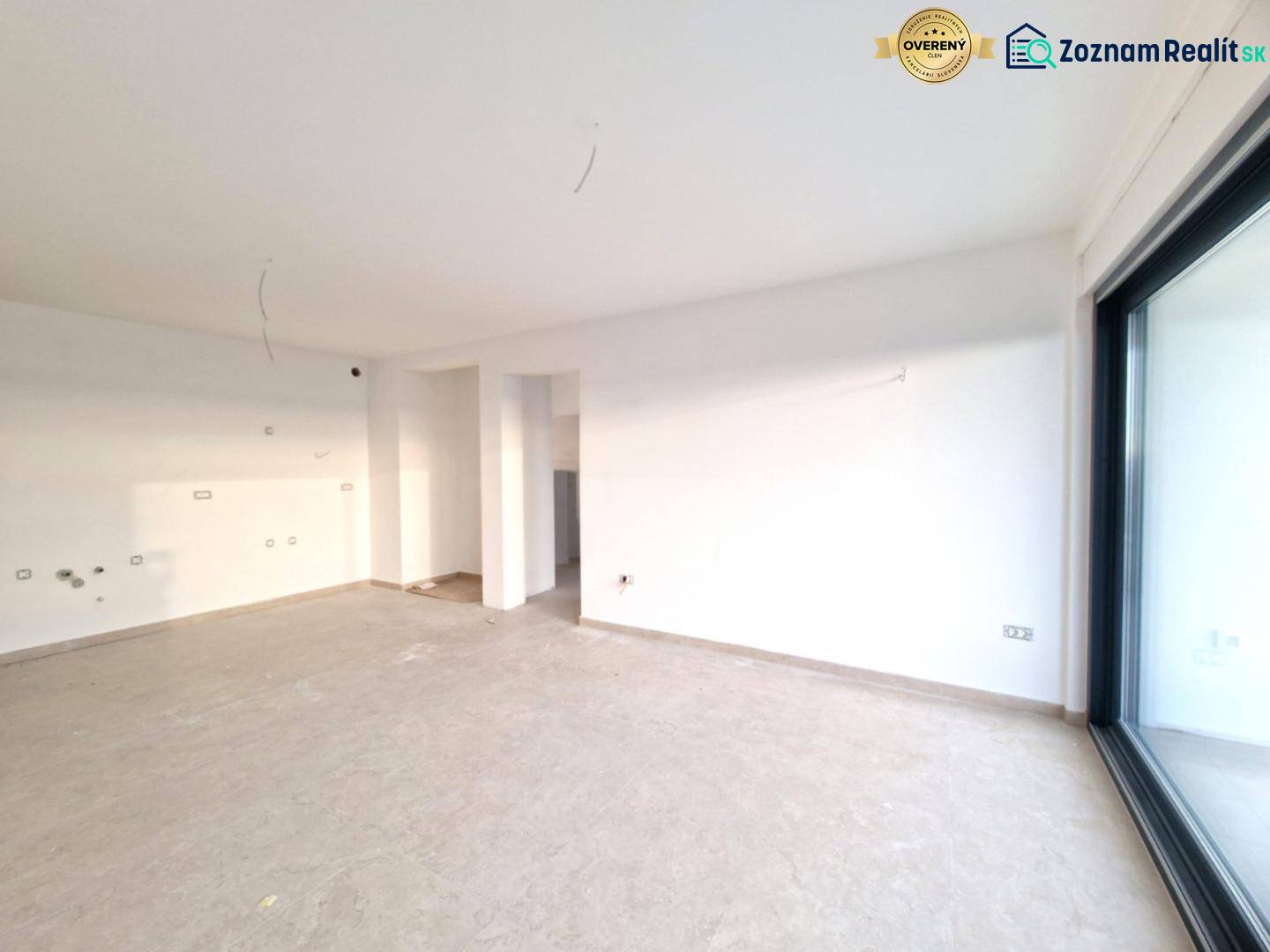 A spacious room in a 3-room apartment with large glass doors and light-colored walls.