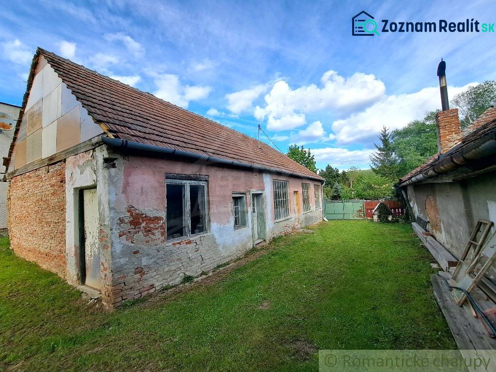 A family house in Horné Lefantovce with a brick facade, surrounding greenery, blue sky.