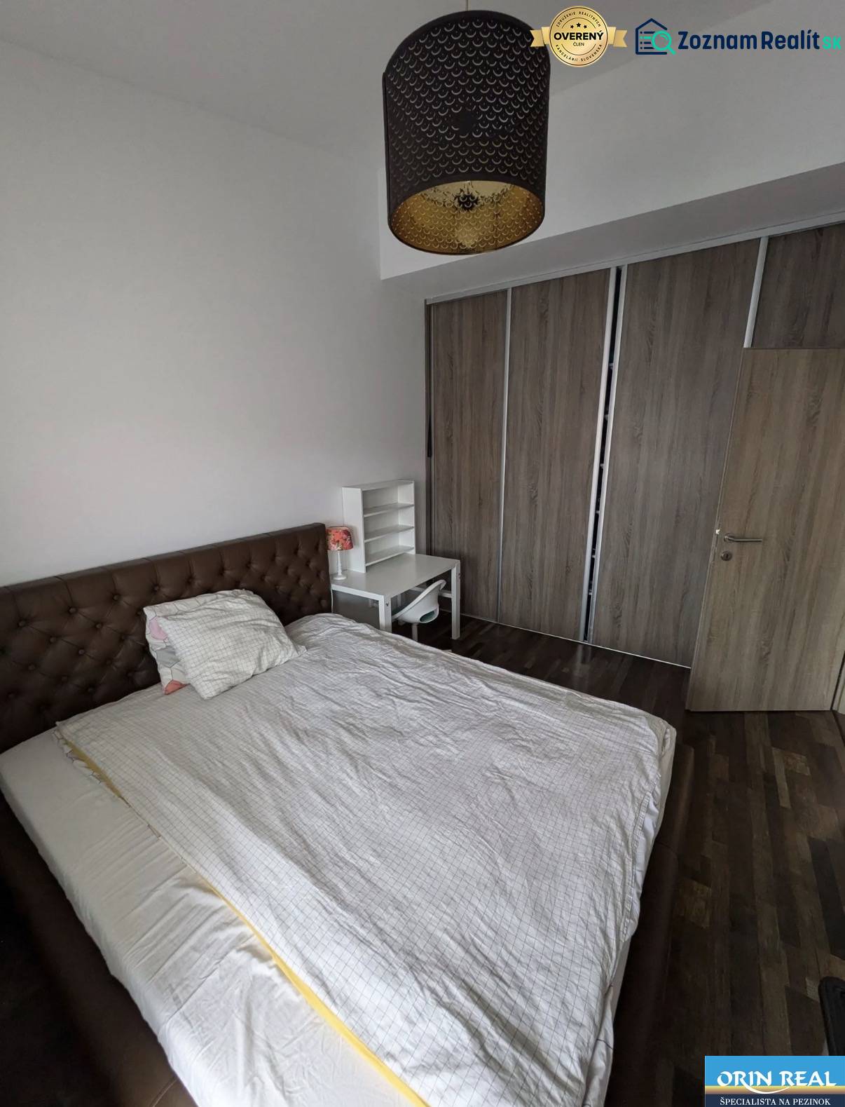 Bedroom with a bed, table, and wardrobe, 2-room apartment, floor with wood decor.