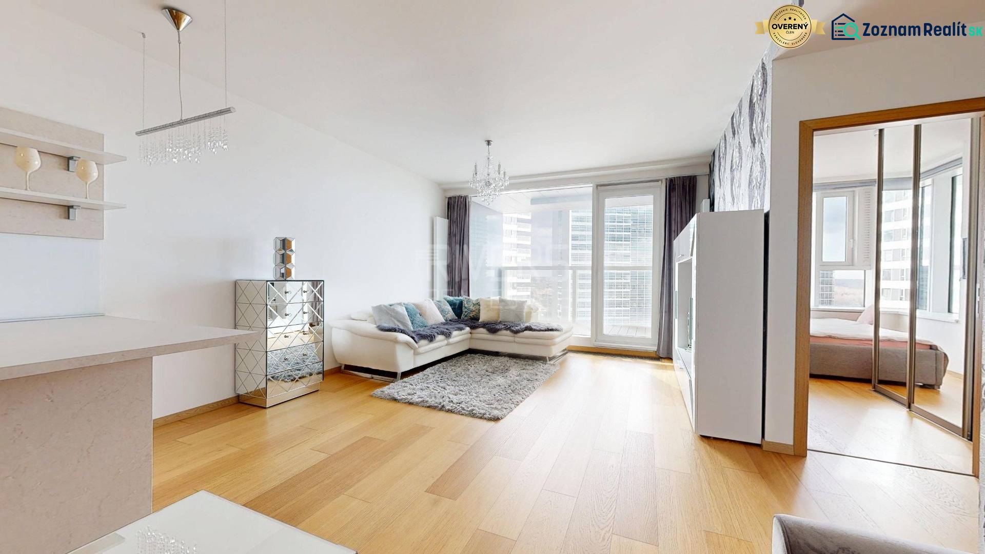 Living room in a two-room apartment with a wooden decor floor and a comfortable sofa.