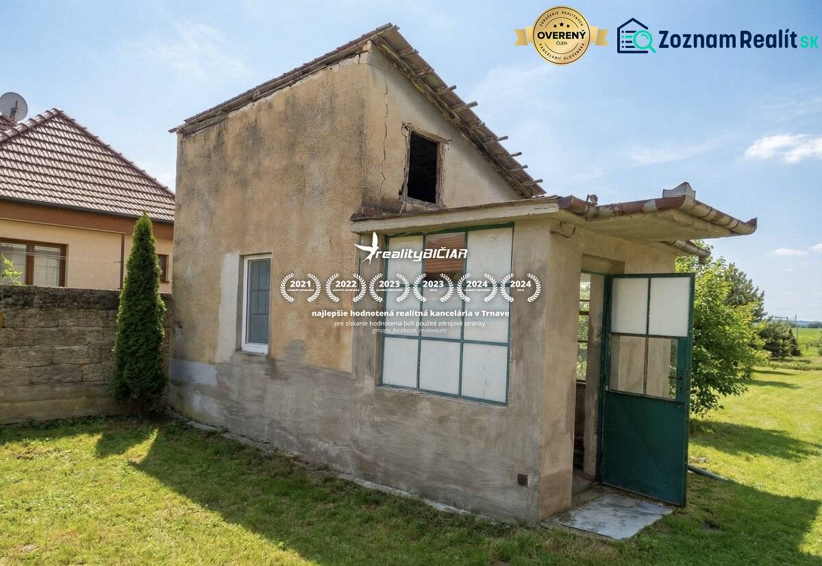 The back part of a family house in Siladice with open doors and a lawn.