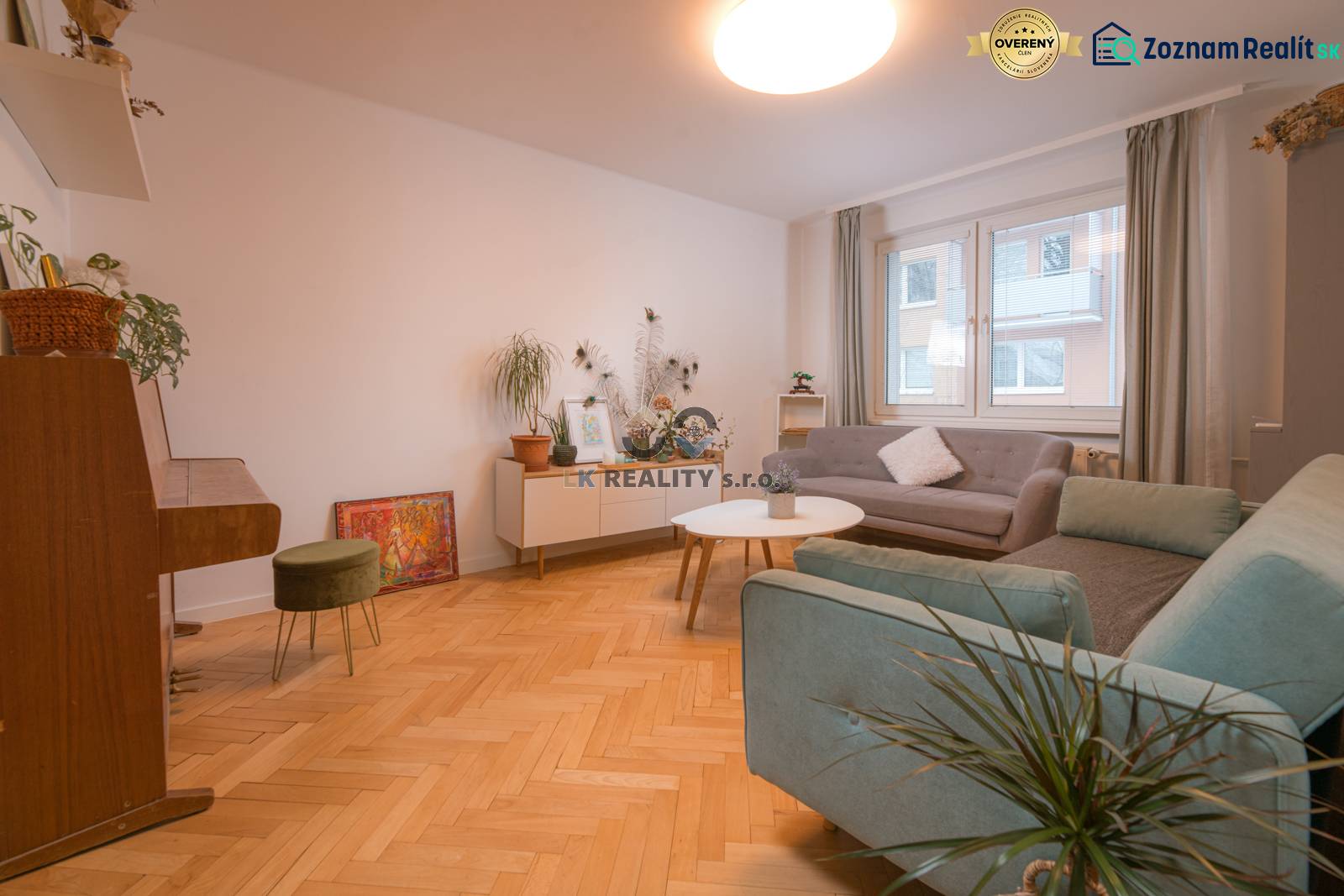A bright living room with a piano, wooden decor flooring, and comfortable sofas.
