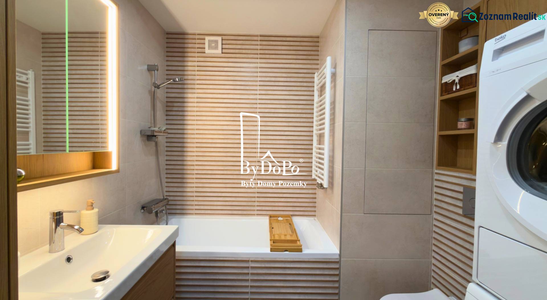 Bathroom in a 2-room apartment with a bathtub, sink, washing machine, and storage space.