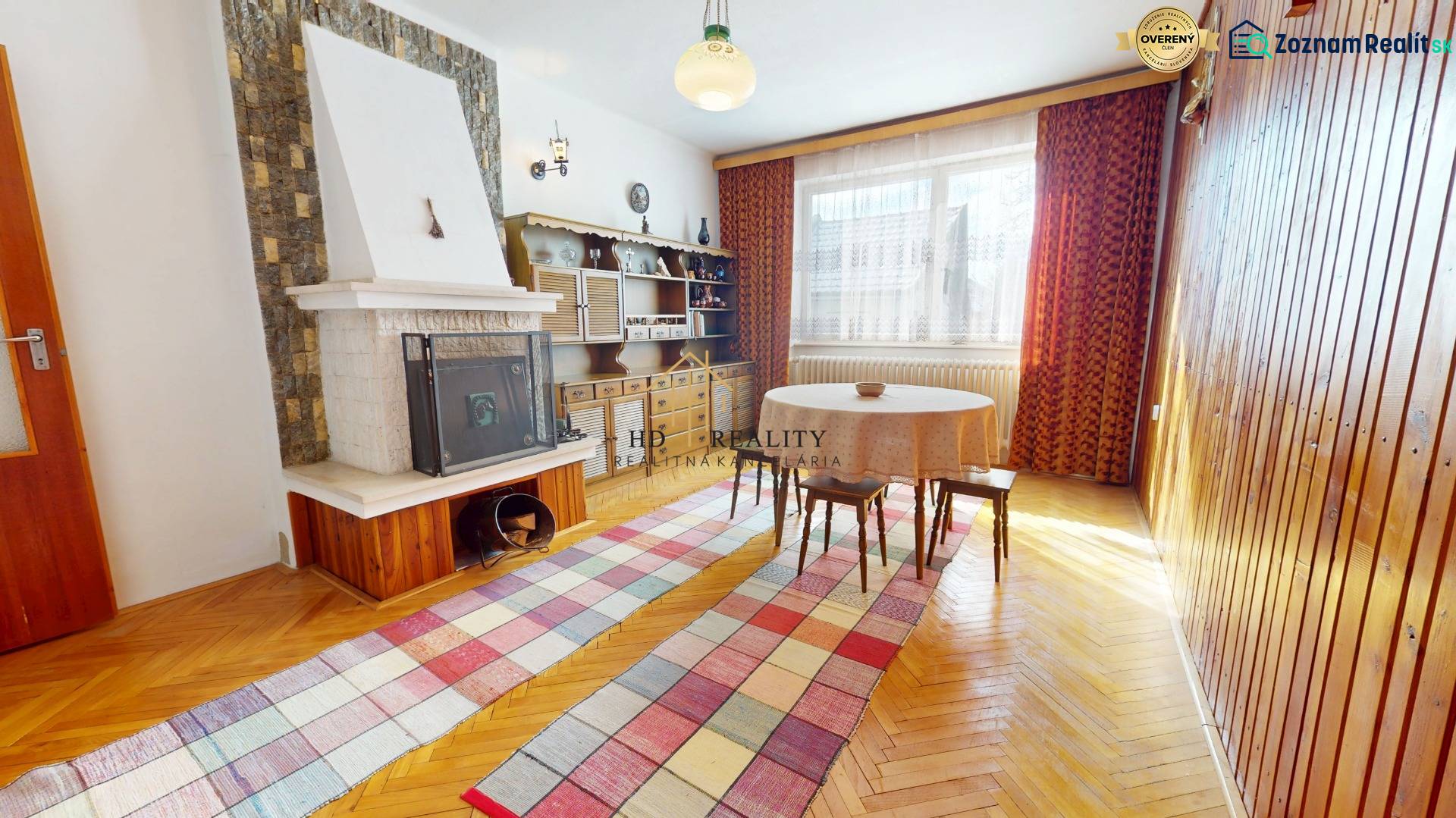 A dining room in a family house with a fireplace, a rustic living room wall, and a floor with a wooden decor.
