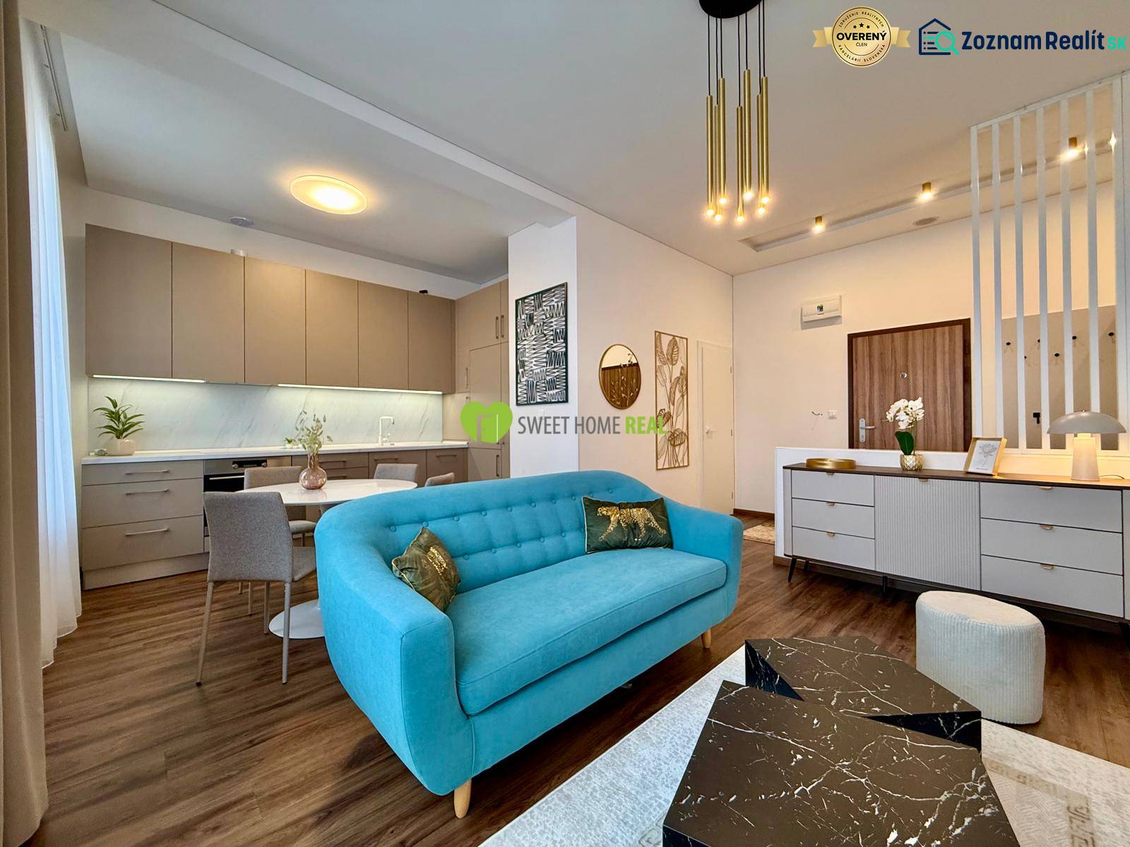 Living room in a two-room apartment with a wooden decor floor and a blue sofa.