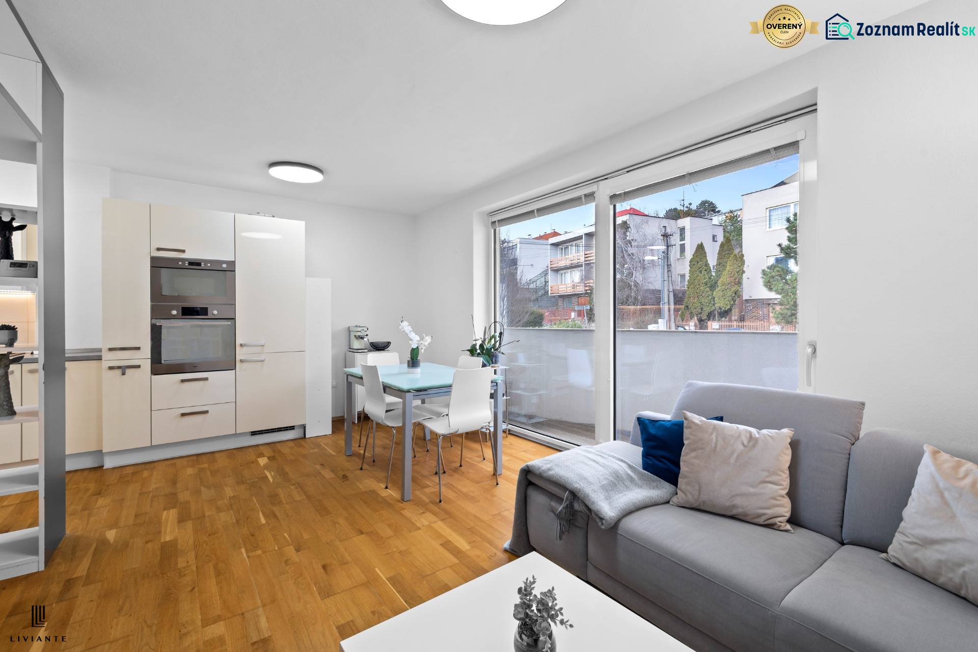 Living room with a kitchenette in a 2-room apartment with a wooden decor floor.