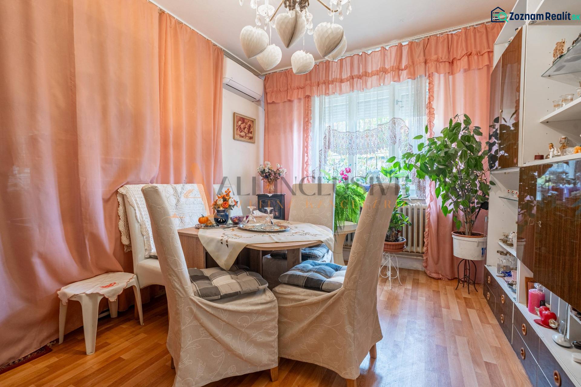 Dining room in a family house, threads on the wall, houseplants, floor with wooden decor.