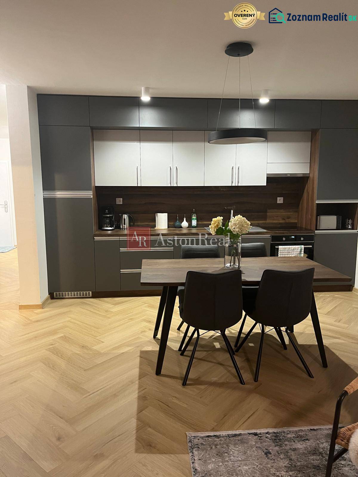 A kitchen in a 3-room apartment with gray cabinets and a wooden decor floor.