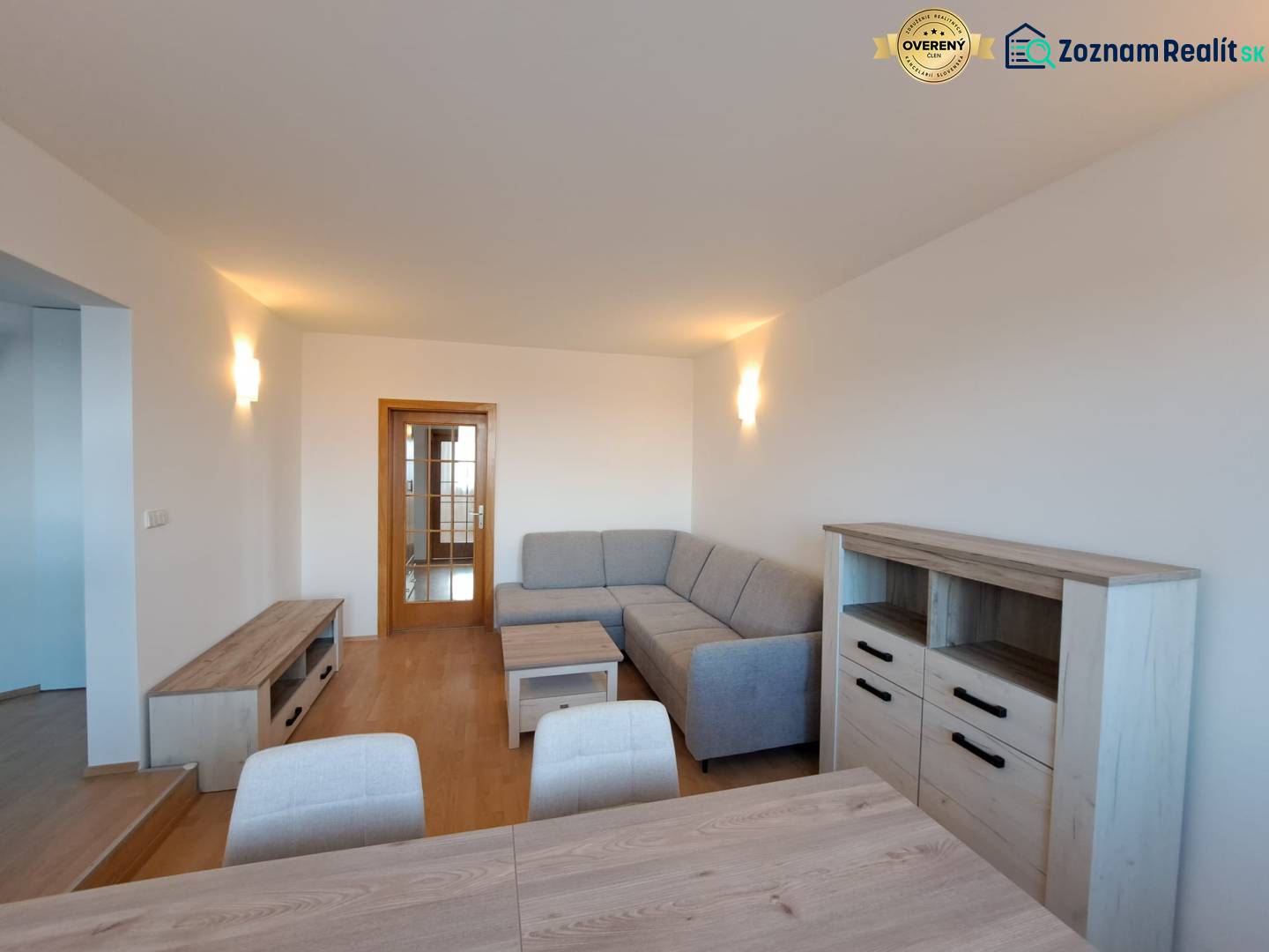 Living room in a 4-room apartment with a wooden decor floor and a gray sofa.