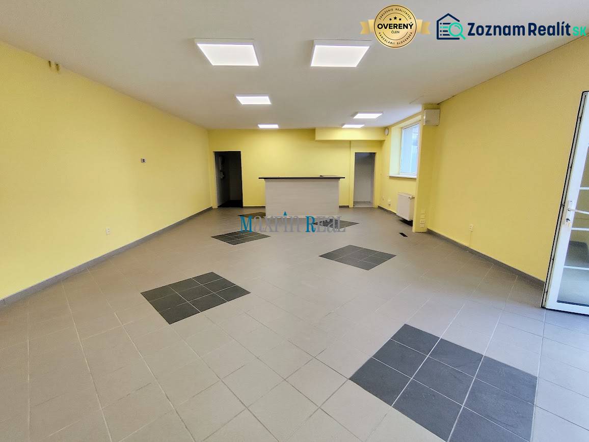 Interior of commercial spaces with tiled flooring and a reception area, illuminated by ceiling lights.