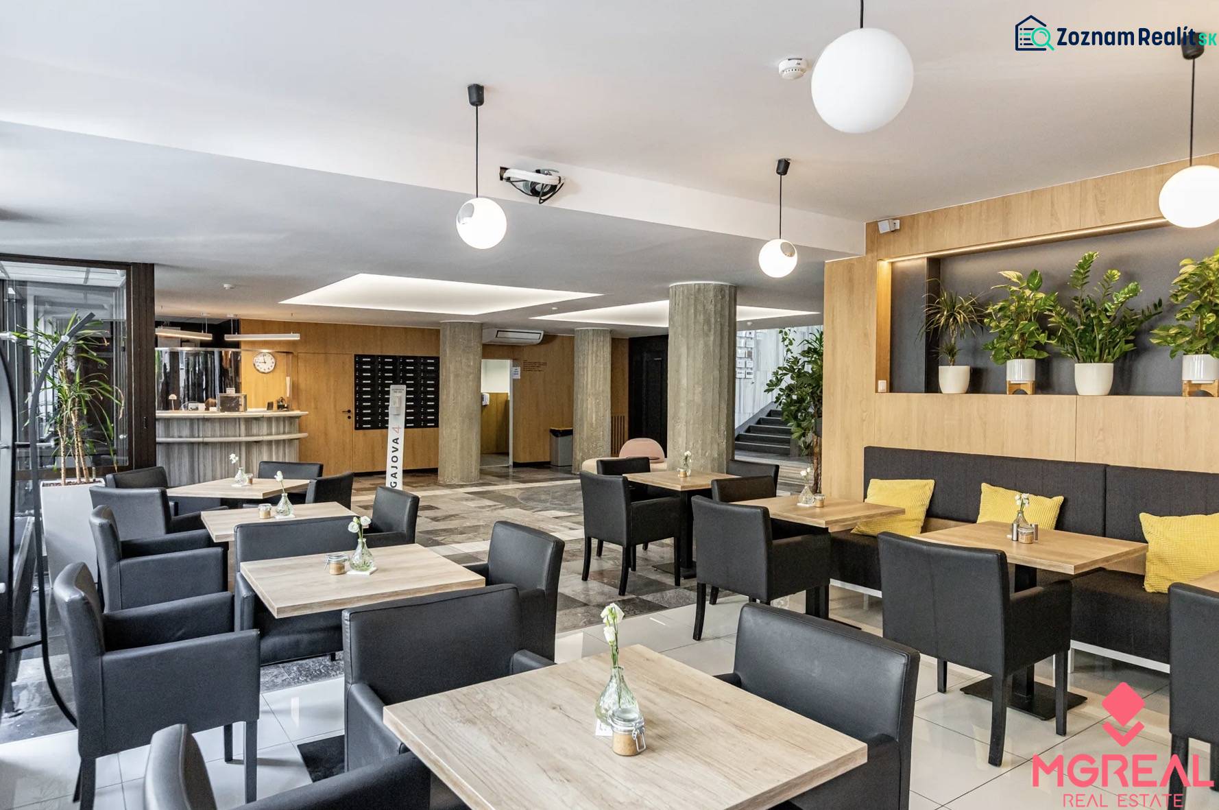 Offices with wood-patterned flooring, desks, black chairs, and plants in Bratislava.