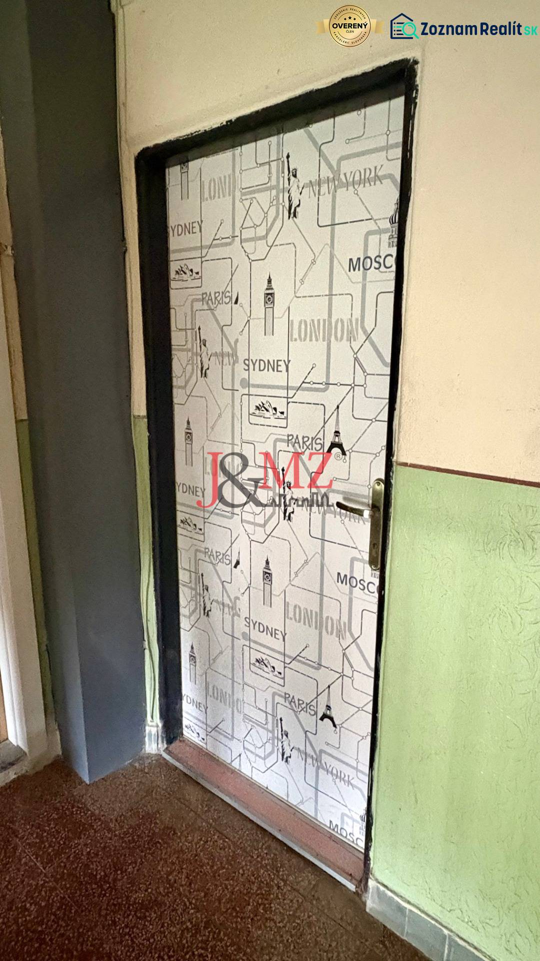 Doors covered with a city motif, floor with a wooden decor, wall in a deep green color.