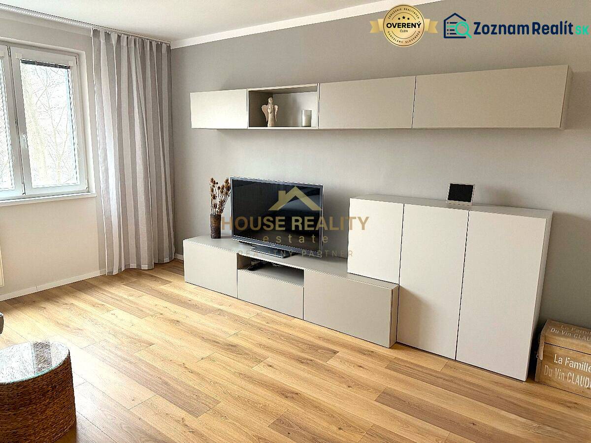 Living room of a three-room apartment with an elegant furniture set and a floor with a wood decor.