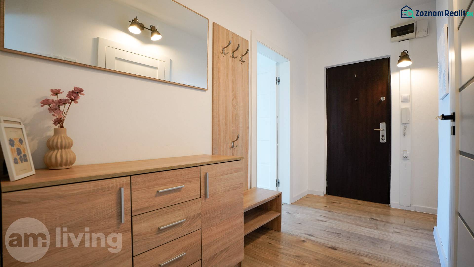 Hallway in a 3-room apartment with a wooden decor floor and wooden furniture.