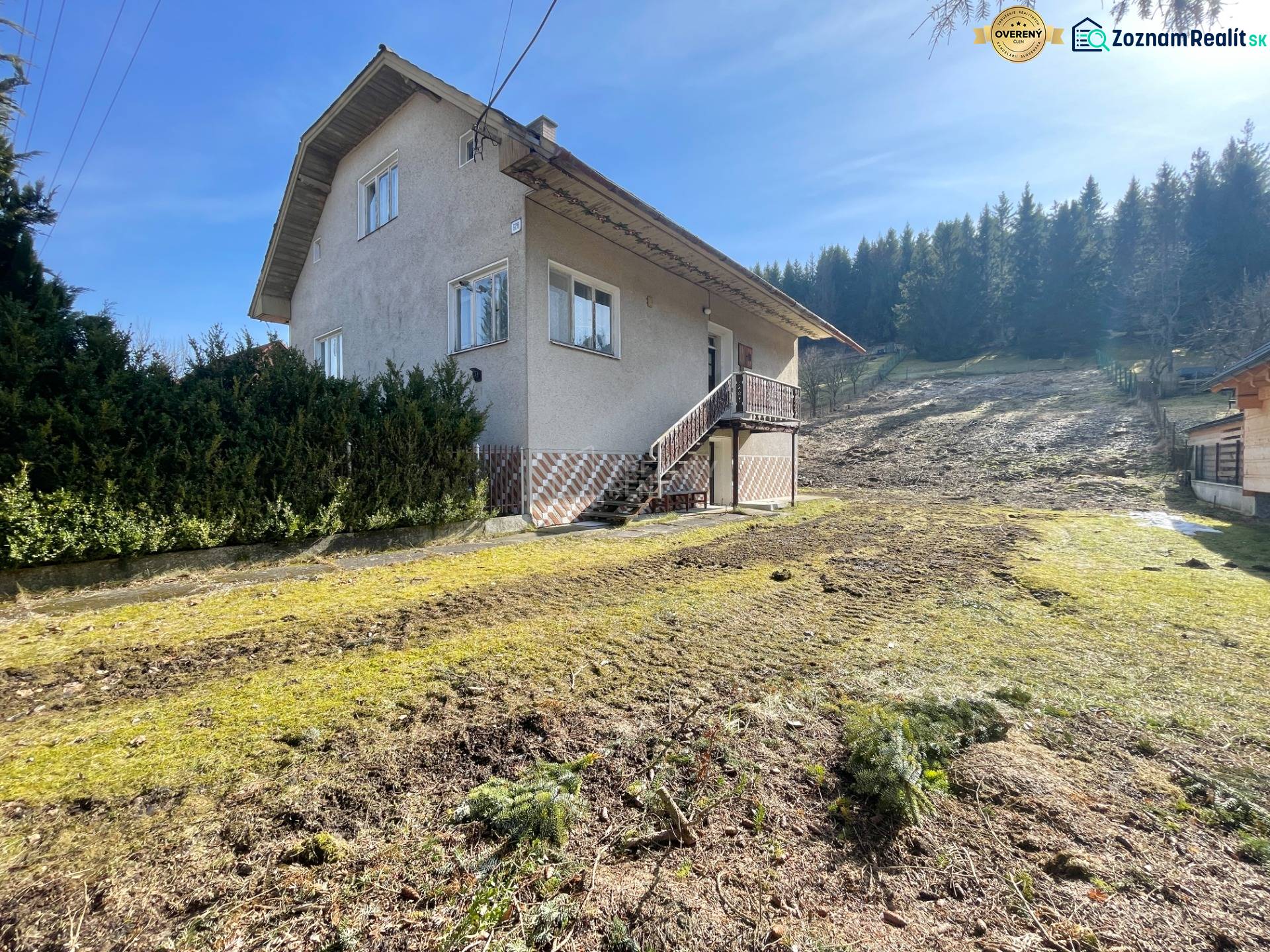 A family house in Terchová with a large grassy plot, surrounded by trees.
