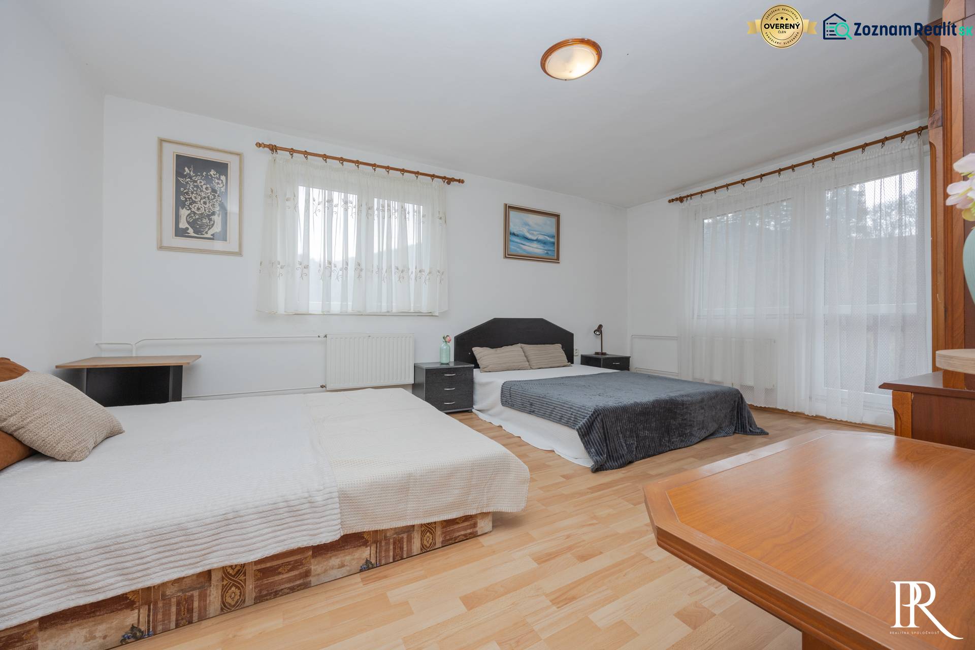 A bedroom in a family house with two beds and a floor with a wooden decor.