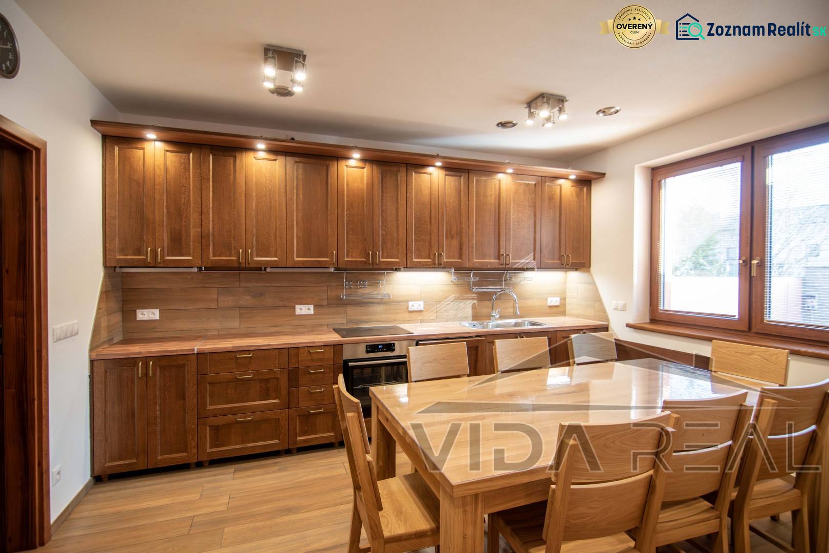A kitchen in a family house with a wooden decor, equipped with wooden furniture and a dining table.