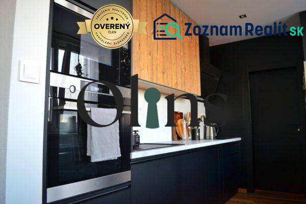 A kitchen in a 3-room apartment with black cabinets and a built-in oven, floor with wood decor.