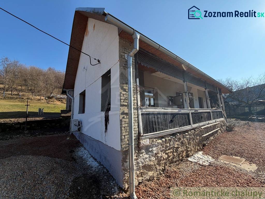 The exterior of a family house in Ratkovské Bystré with sunny weather and a stone base.