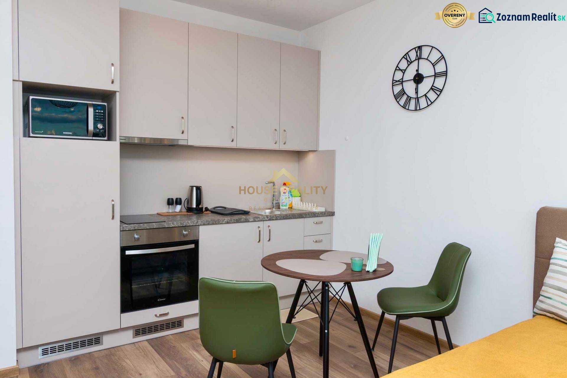 Kitchen in a studio apartment with a wooden decor floor and a dining table.