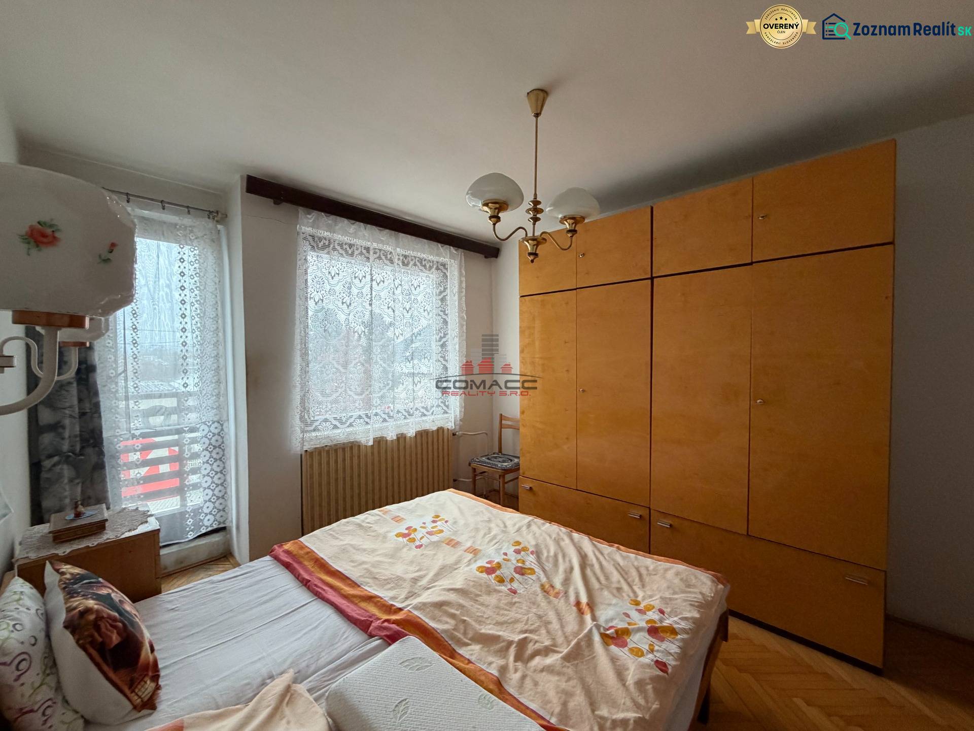 Bedroom with a double bed, furniture, and wood-patterned flooring in a family house.