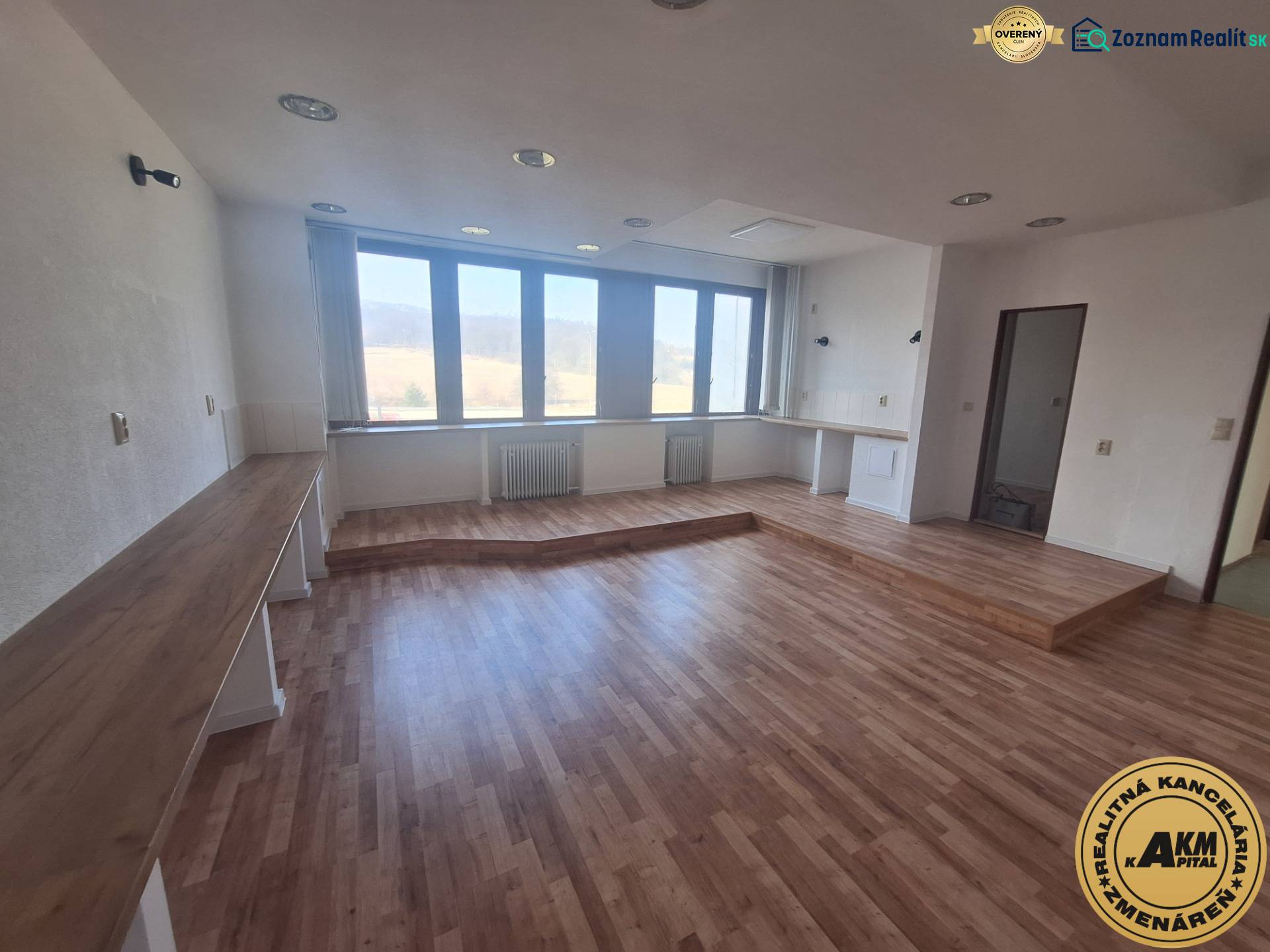 Commercial spaces with wood-patterned flooring and large windows.