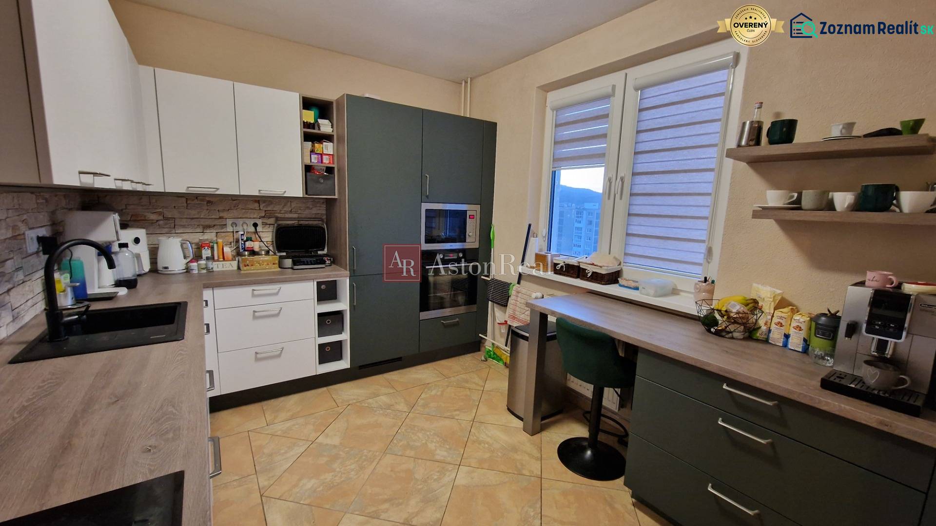 A kitchen in a 3-room apartment with a floor and kitchen cabinets with a wooden decor.