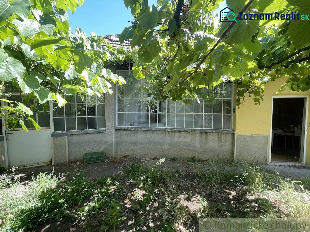 A family house in Tvrdošovce with a veranda surrounded by greenery, a garden with vines.