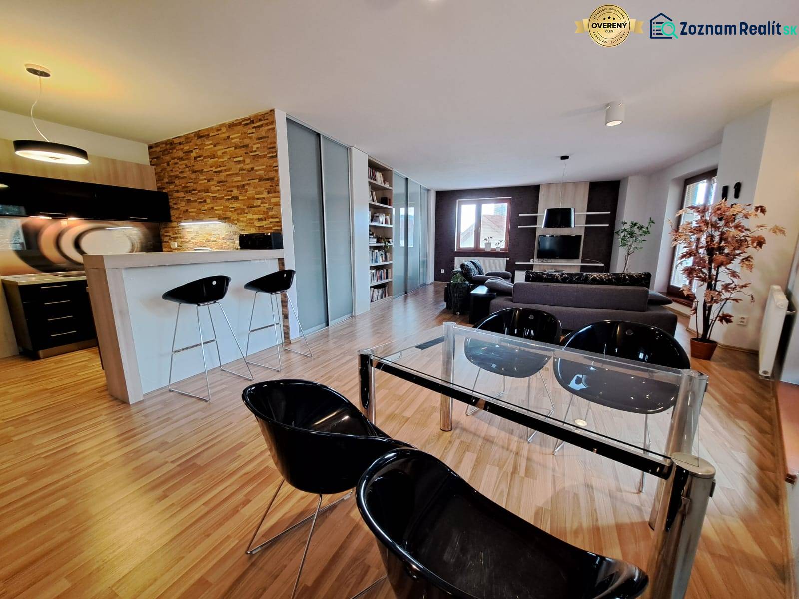 Open space of a 2-room apartment with a kitchen counter and a wooden decor floor.