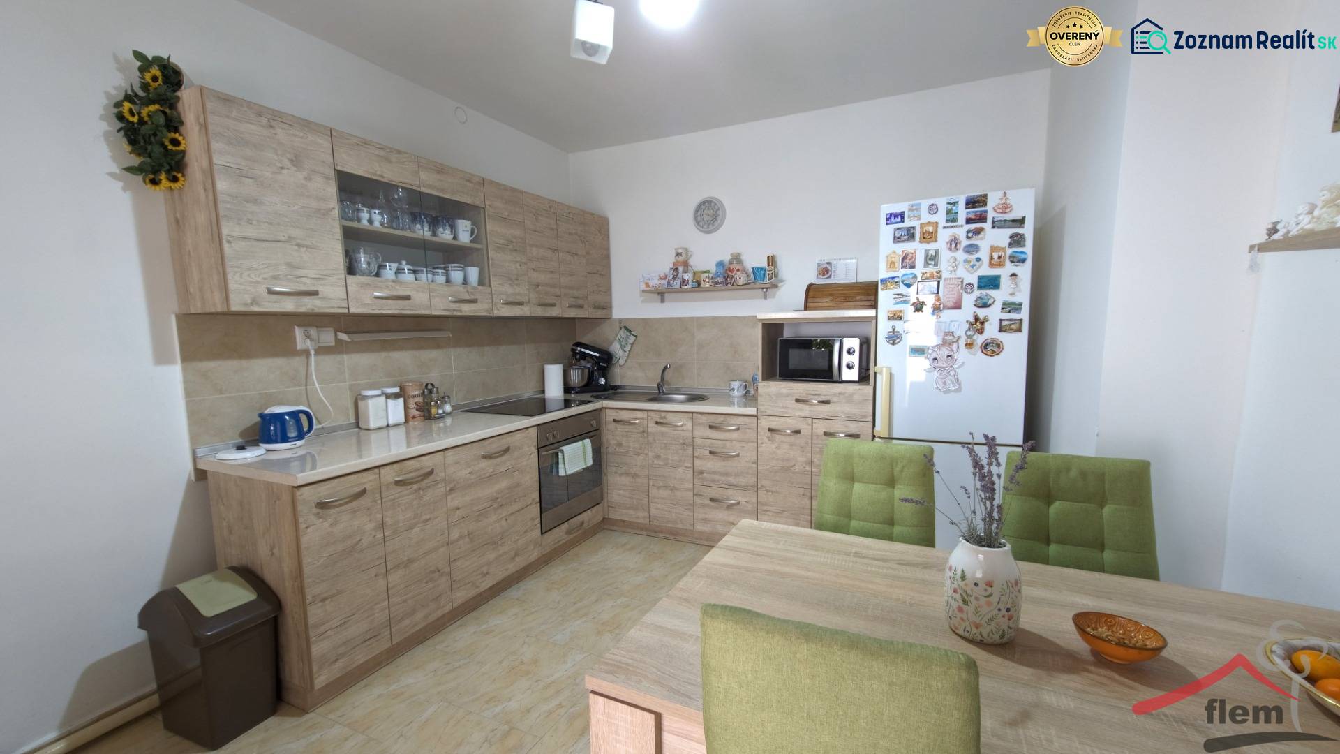 A kitchen in a family house with wooden decor furniture, green chairs, and decorations.