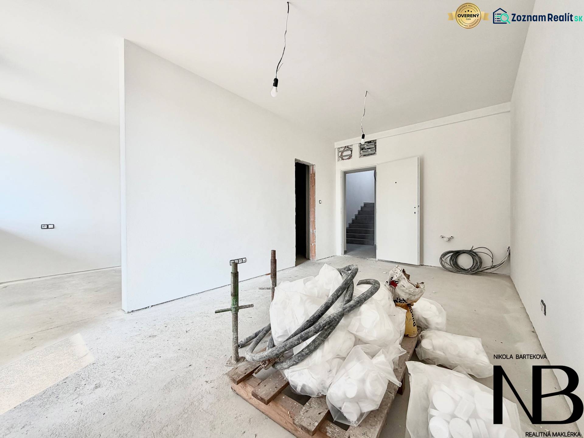 A one-room apartment with white walls and a concrete floor.