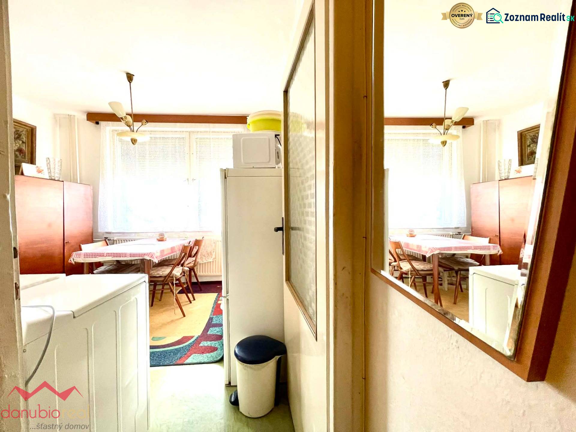 A dining room with wooden decor, a kitchen table, and a mirror in a studio apartment.