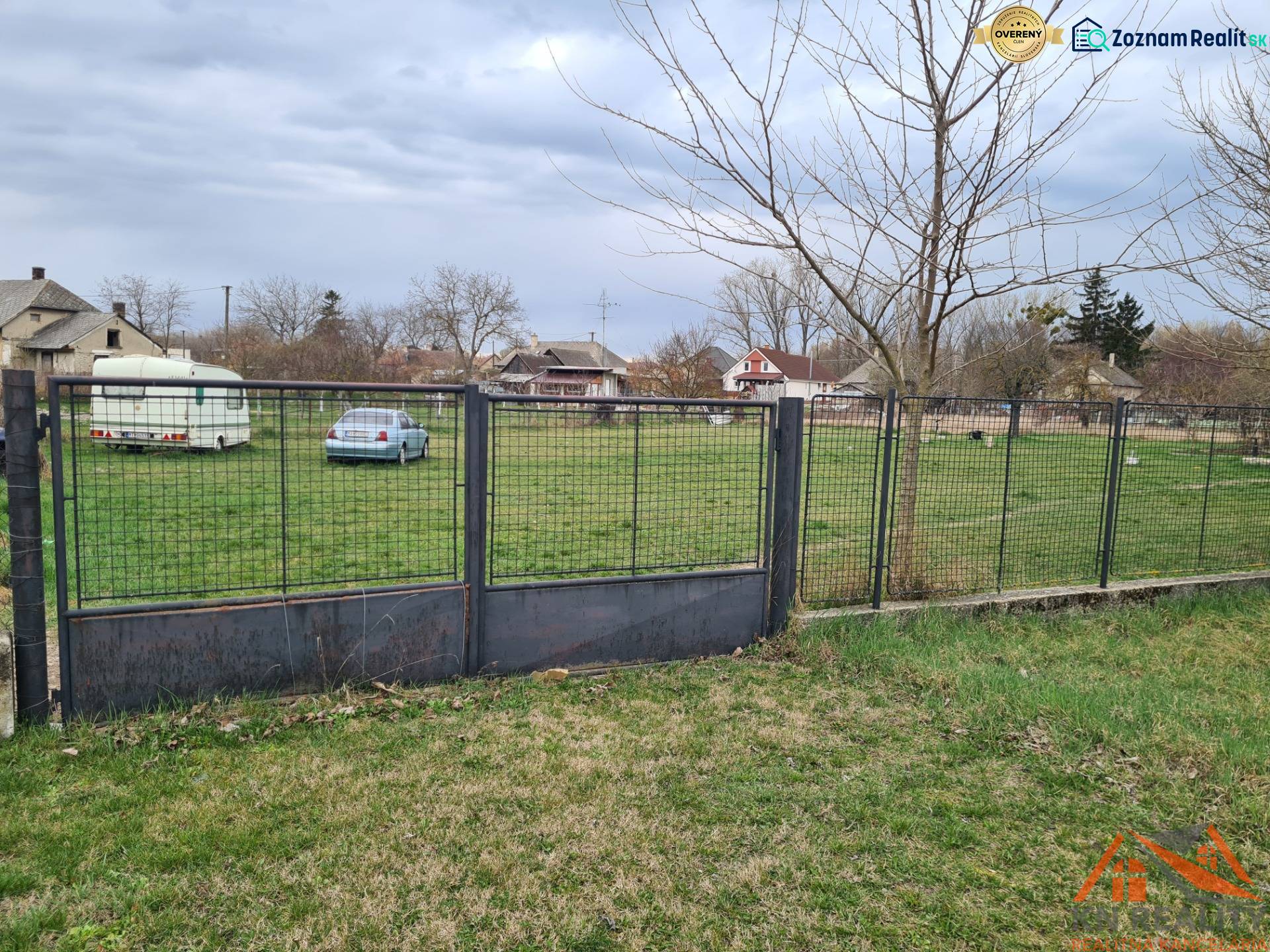 Plot surrounding a residential plot in Veľké Kosihy with a car and a trailer.