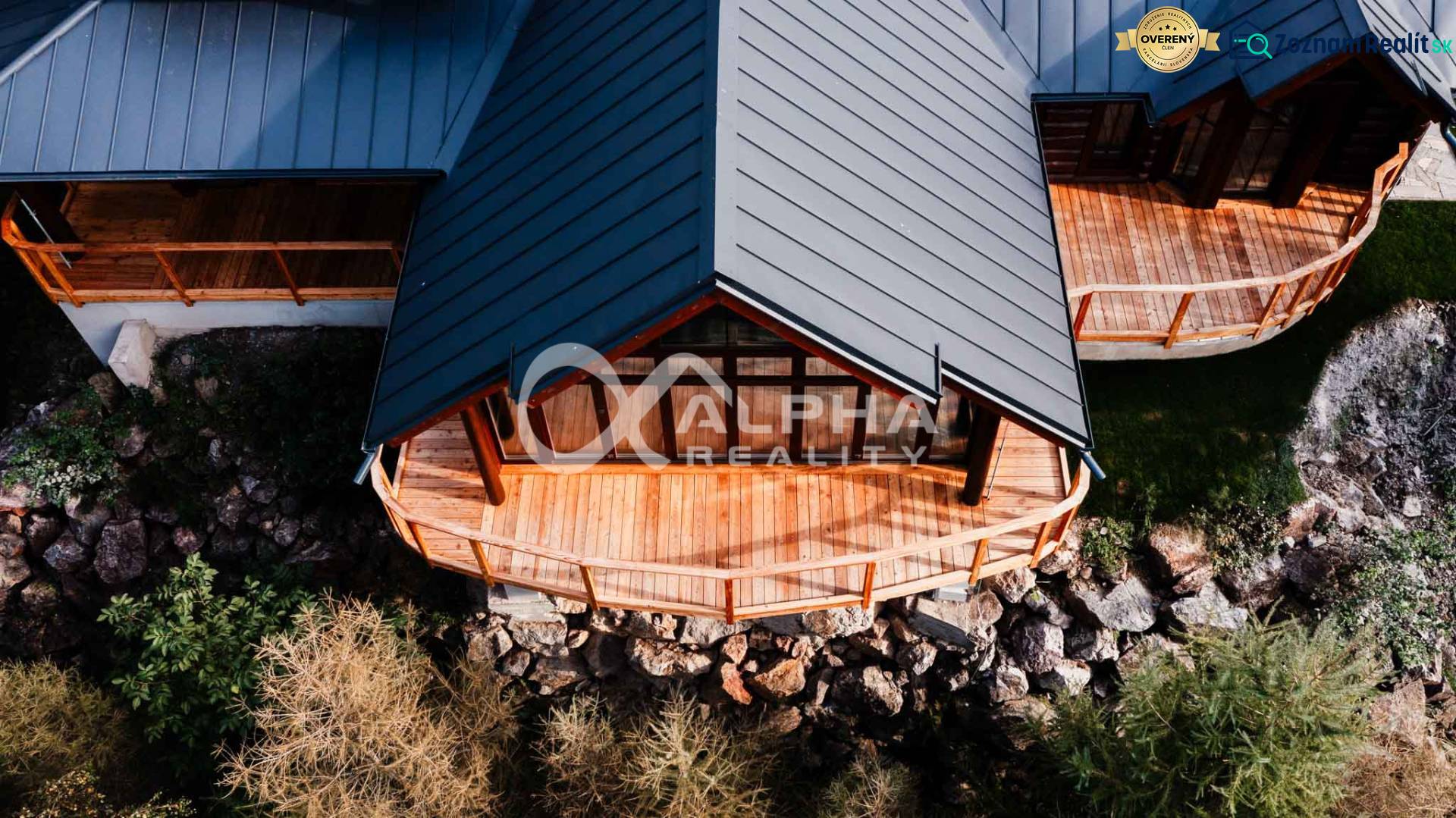 A family house in Hnilčík with a wooden terrace and a sloped roof among natural elements.