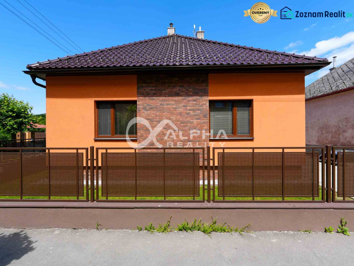 A family house in Spišská Nová Ves with an orange facade and a brown fence.