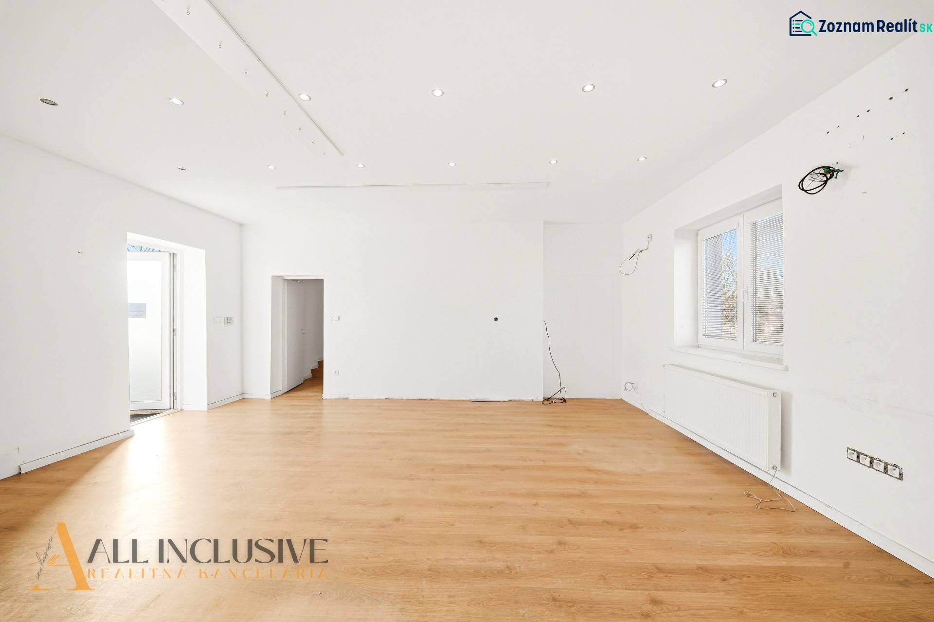 Spacious commercial spaces with white walls and a floor with a wooden decor.