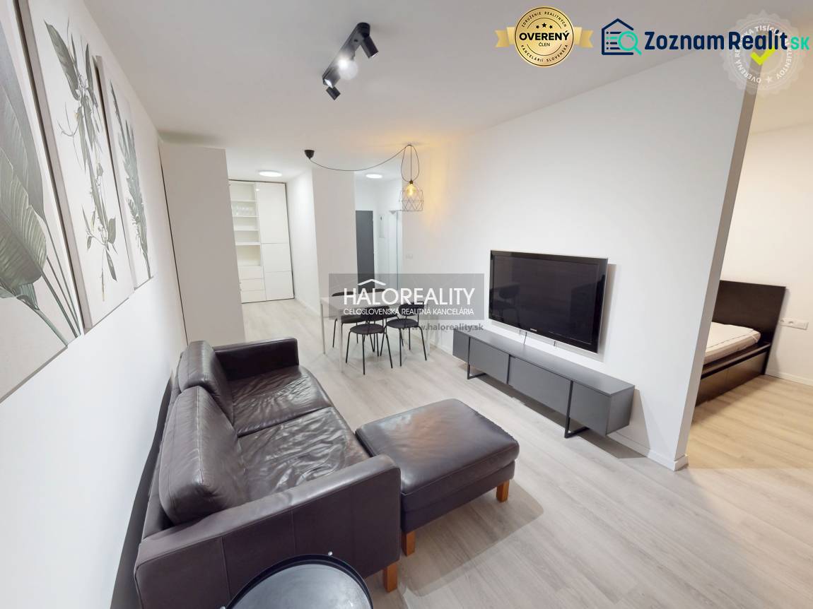 Living room with a leather sofa in a two-room apartment and a floor with a wooden decor.