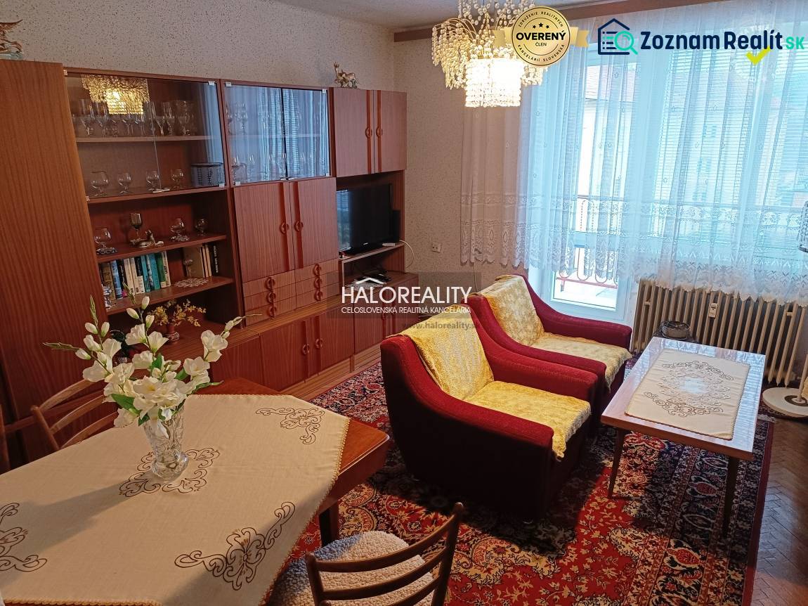 Living room with a sofa, television, and floral decorations in a 2-room apartment.