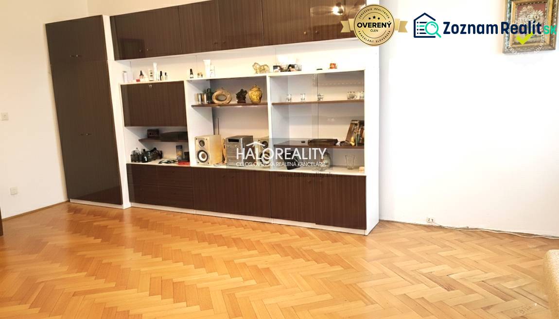 Living room wall unit with cabinets and wooden decor flooring in a 3-room apartment.