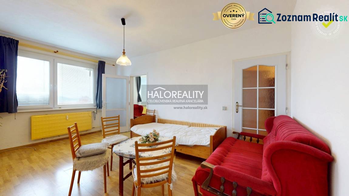Living room in a three-room apartment with a wooden decor floor, sofa, and table.