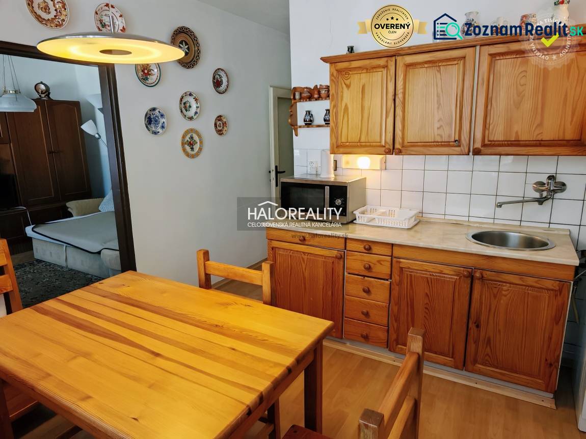 Dining room in a 3-room apartment with a kitchen unit and wooden decor furniture.