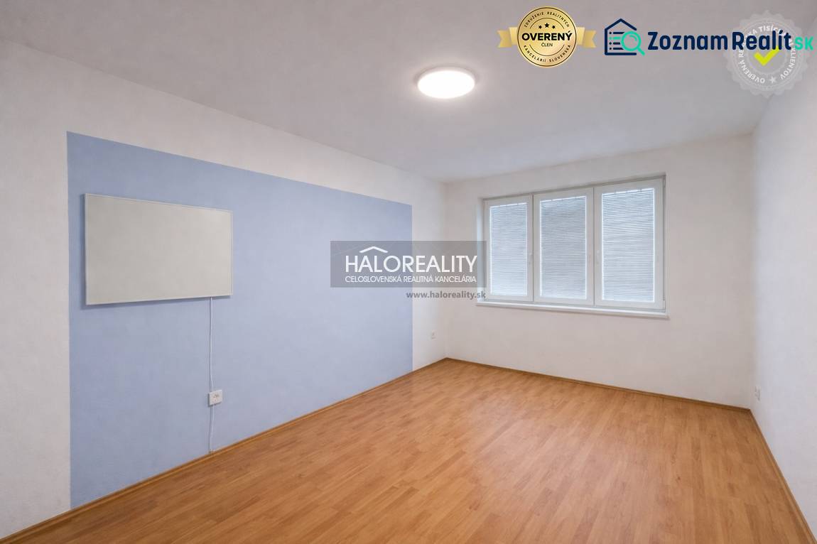 A room in a 4-room apartment with a wooden decor floor and a large window.