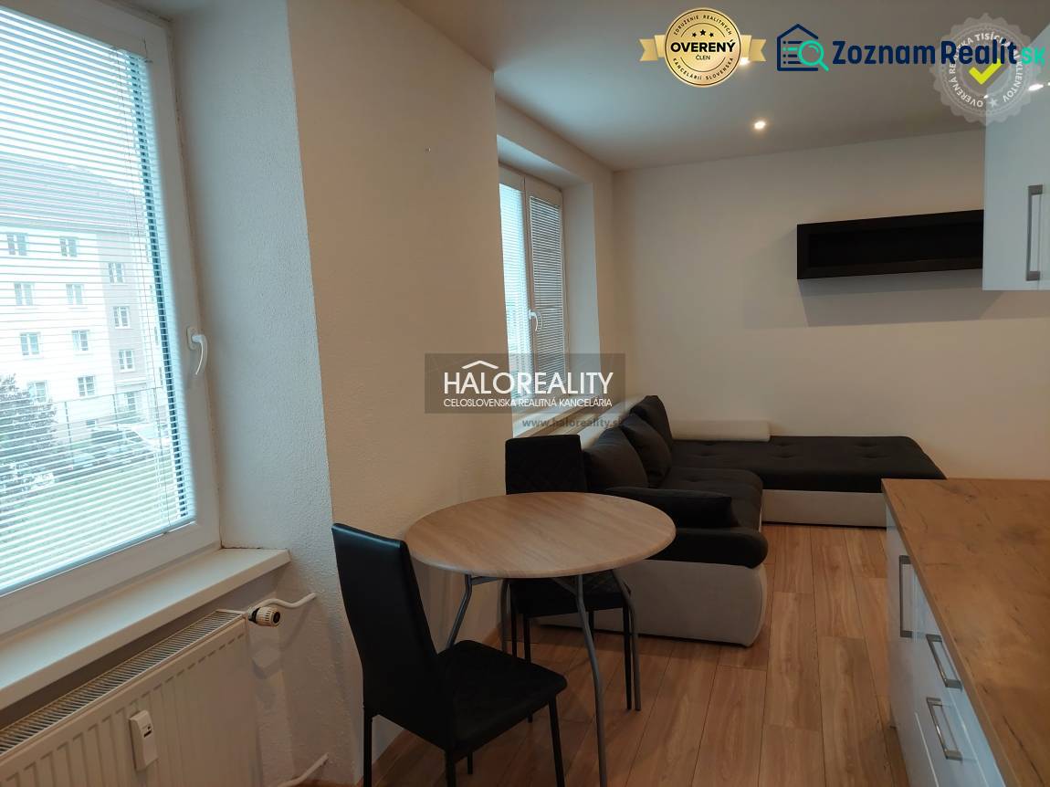 Bright living room in a two-room apartment with wood-patterned flooring.