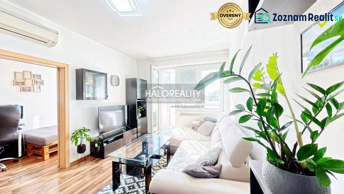 Living room in a 3-room apartment with a wooden decor floor and a white sofa.