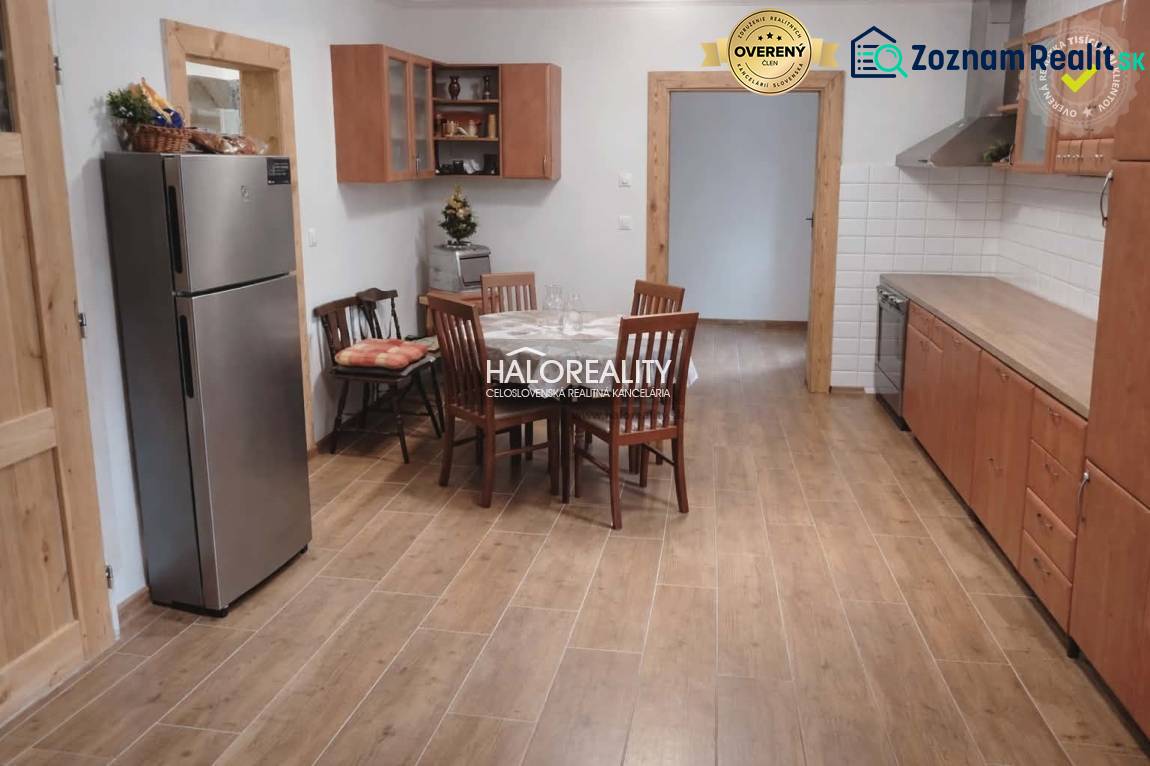 A kitchen in a family house with a dining table and a wooden-patterned floor.