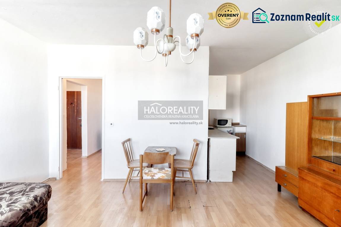 Dining table with chairs in a 2-room apartment, floor with wooden decor, white interior.